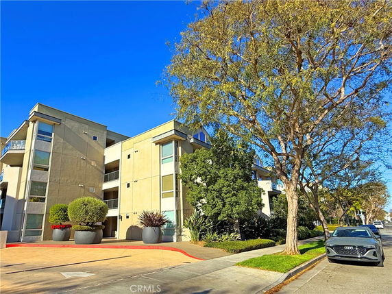 Front view of a modern apartment building with multiple stories and balconies.