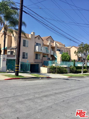 Front view of a multi-story apartment building with balconies.