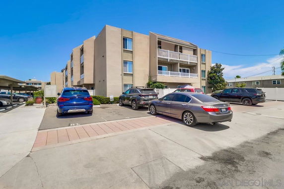 Outdoor parking area in front of a multi-story building.