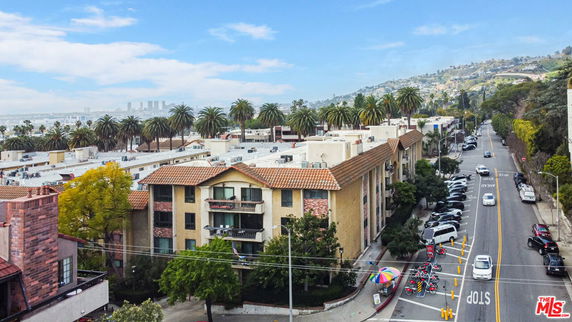 Front view of a mid-rise building with balconies and a gabled roof.
