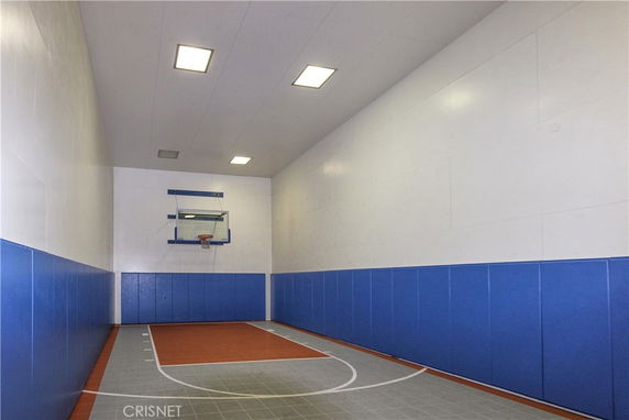 Indoor basketball court with blue padded walls.