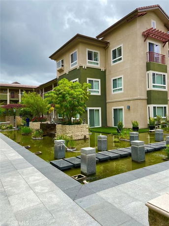Front view of a modern multi-story apartment building with green accents.