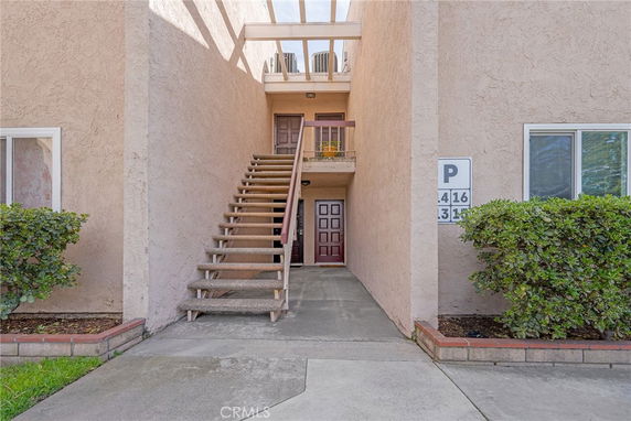 Front view of a building entrance with stairs leading to an upper floor.