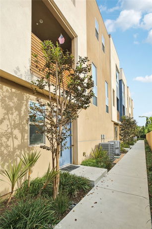 Front view of a modern multi-story townhouse building with beige and blue elements.