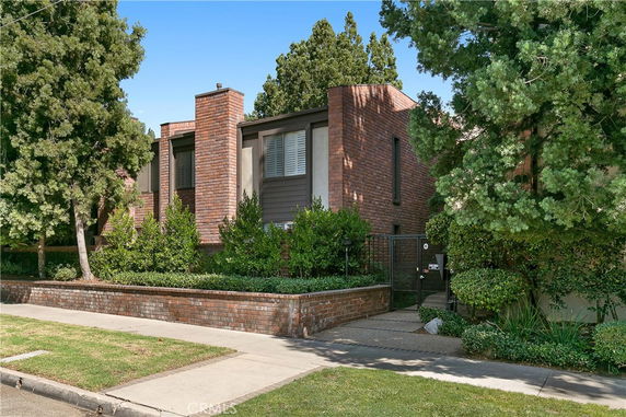 Front view of a two-story house with brick exterior and a gated entrance.