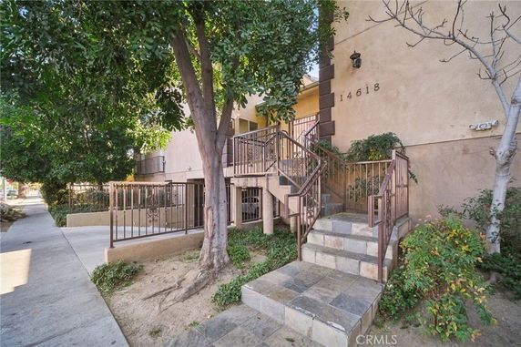 Front view of a residential building with stairs leading to the entrance.