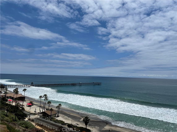Panoramic view of a coastal area with a pier extending into the ocean.