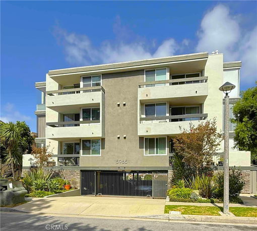 Front view of a multi-story apartment building with balconies.