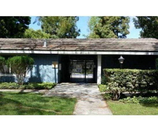 Front view of a single-story house with a gated entry and a shingled roof.
