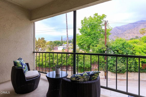 Balcony view overlooking greenery and distant mountains.