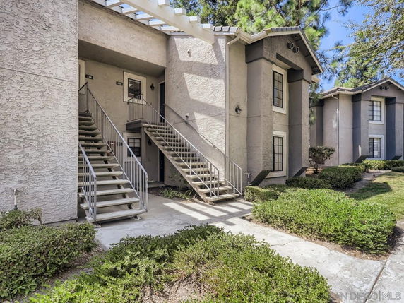 Front view of a multi-story residential building with exterior staircases.