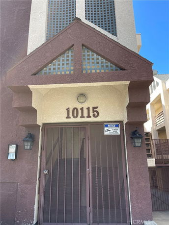 Front view of a building entrance with the number 10115 and security features.