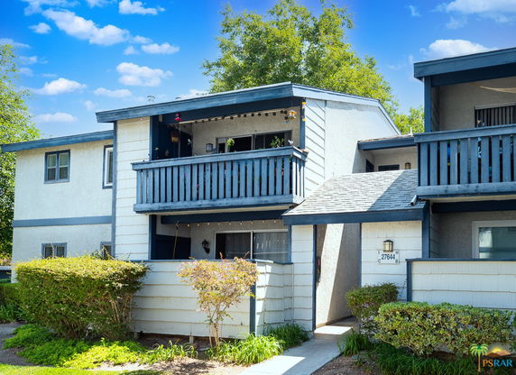 Front view of a townhouse with two stories and a balcony.