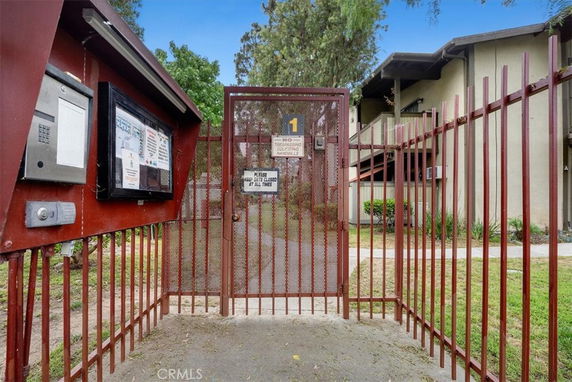 Entrance gate leading to a multi-story residential building.