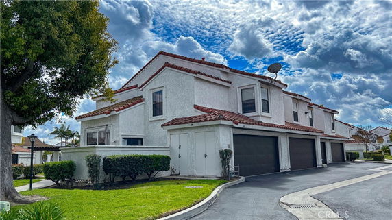Front view of a two-story house with a multi-unit garage and tiled roof.