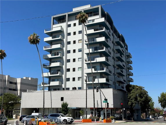 Front view of a multi-story apartment building with balconies.
