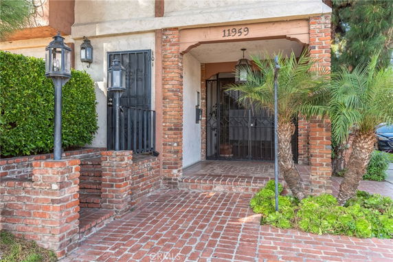 Front entrance of a house with brick pathway and lanterns.