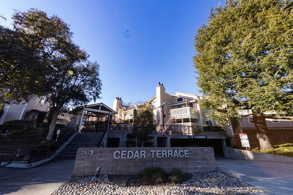 Front view of a multi-story residential building with stairway entrance.