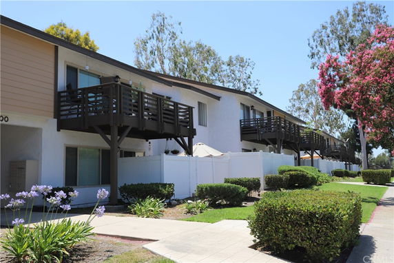 Front view of a row of two-story townhouses with balconies.