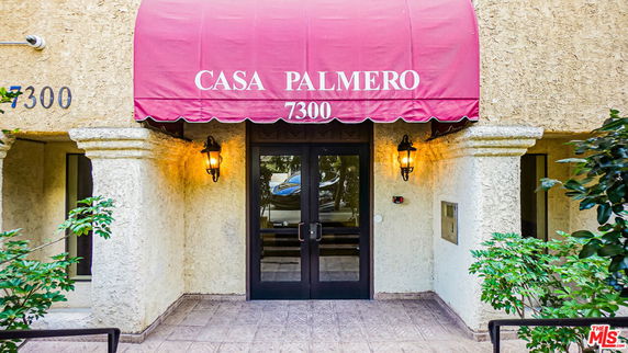 Front entrance of a building with a red canopy labeled 'Casa Palmero' and the number 7300.