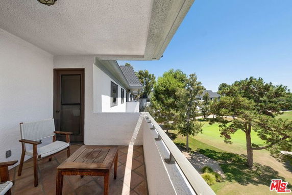 Balcony view of a green landscape and trees from a building.