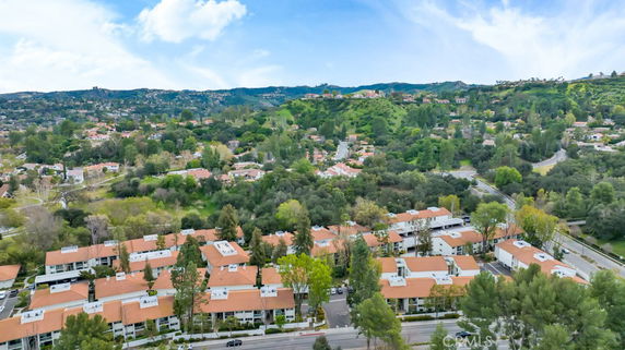 Aerial panoramic view of a residential area with multiple buildings and surrounding greenery.