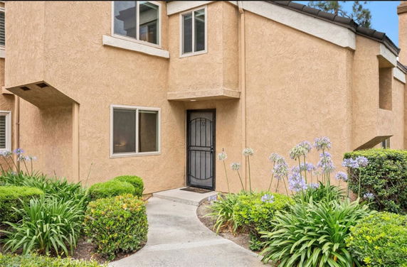 Front view of a two-story house with beige stucco exterior.