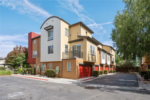 Front view of a multi-story apartment building with red garage doors.
