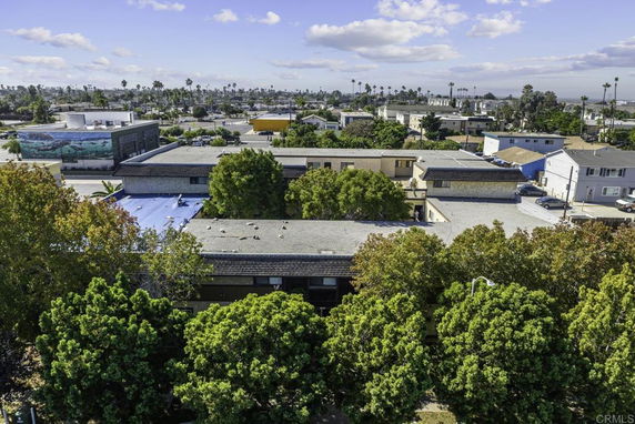 Aerial view of a residential area with trees and various buildings.