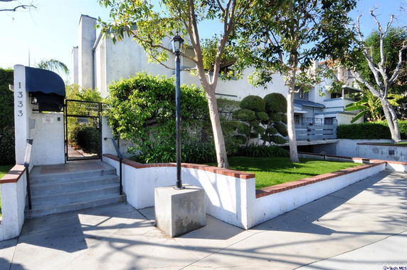 Front view of a building with gated entrance and landscaped surroundings.