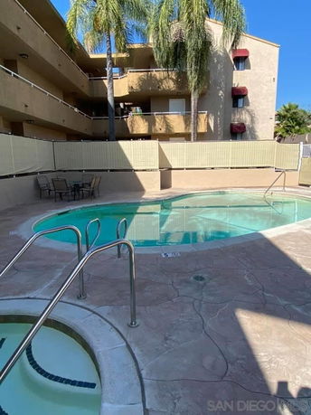 Outdoor area with a swimming pool and surrounding apartment building.