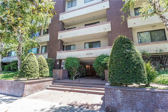 Front view of a multi-story building with brick and stucco exterior.