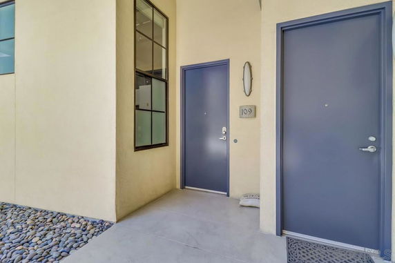 Entrance view of a building with two doors and a window above ground level.