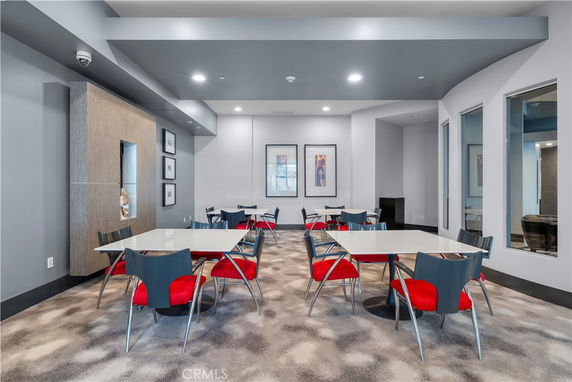 Interior view of a recreational area with tables and chairs, designed for social or leisure activities.