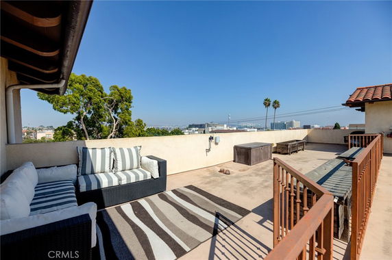 Rooftop view with seating area and surrounding urban landscape.