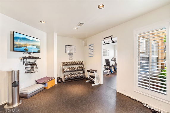 Interior gym area with exercise equipment and weights.