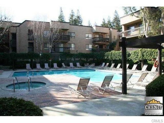 Outdoor swimming pool area surrounded by multi-story buildings.