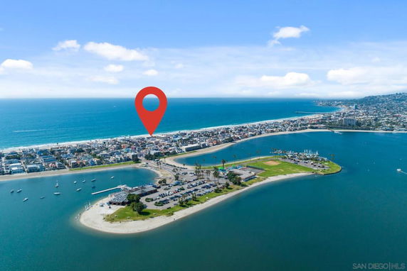 Aerial panoramic view of coastal area with ocean, beaches, and residential neighborhoods.