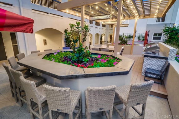 Outdoor recreation area with seating, pergola, and barbecue grill.