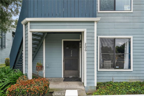 Front view of a two-story residential building with an exterior staircase.