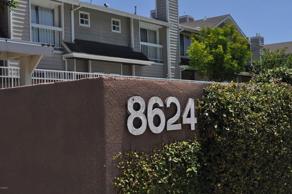 Front view of a multi-story building with balconies and house number 8624.