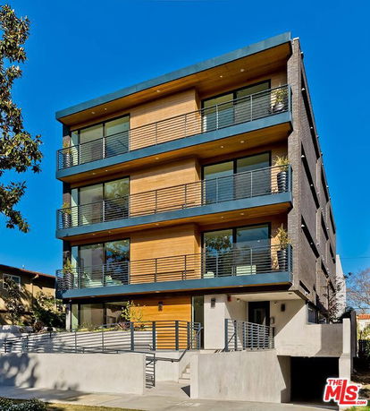 Front view of a modern multi-story apartment building with balconies.