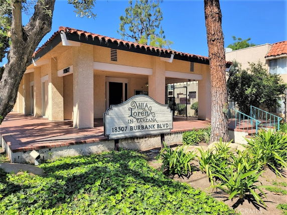 Front view of a building with a red-tiled roof and a sign reading 'Villa Lorena in Tarzana, 18307 Burbank Blvd'.
