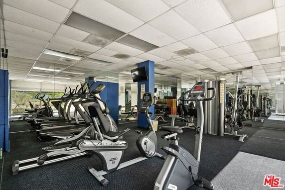 Indoor gym area with exercise equipment and mirrors.