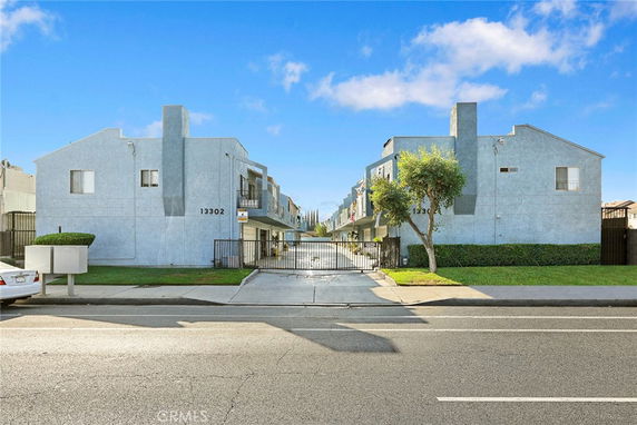 Front view of a multi-story residential building with gated entrance.