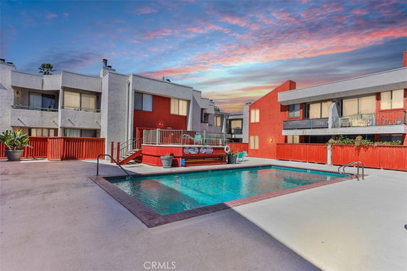 Outdoor swimming pool area surrounded by apartment buildings.