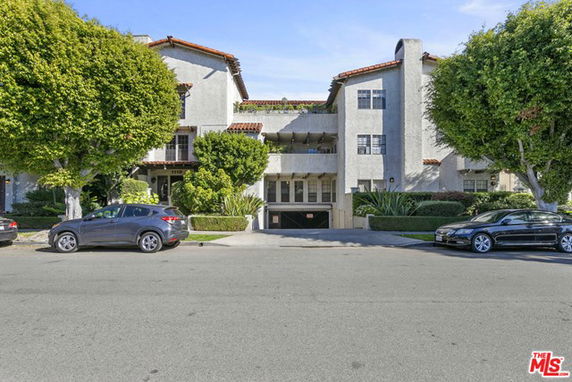 Front view of a multi-story building with red-tiled roofs and a central entrance.