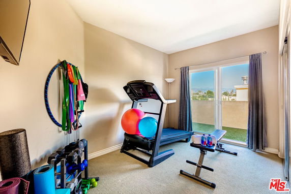 Indoor gym area with exercise equipment and large window.