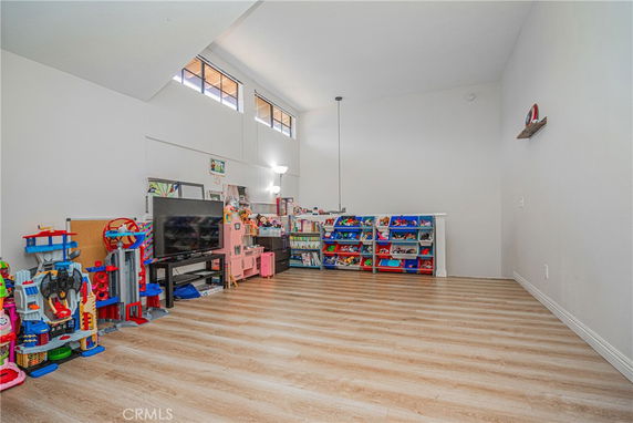 Room with toys, a TV, and shelving units for children's play.