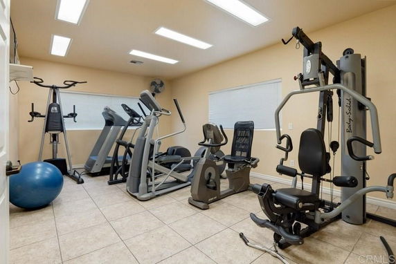 Indoor gym area with various exercise equipment, including treadmills, elliptical machines, and a weight machine.